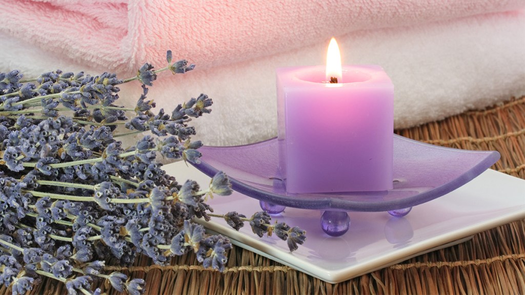 A lavender-scented candle that's lit in a bathroom, which can enhance the mood-boosting benefits of an everything shower