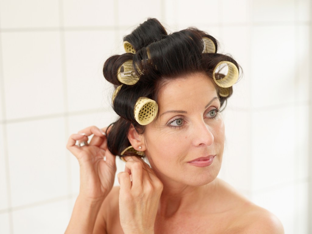 Mature women pinning curls up in rollers to make curls last longer
