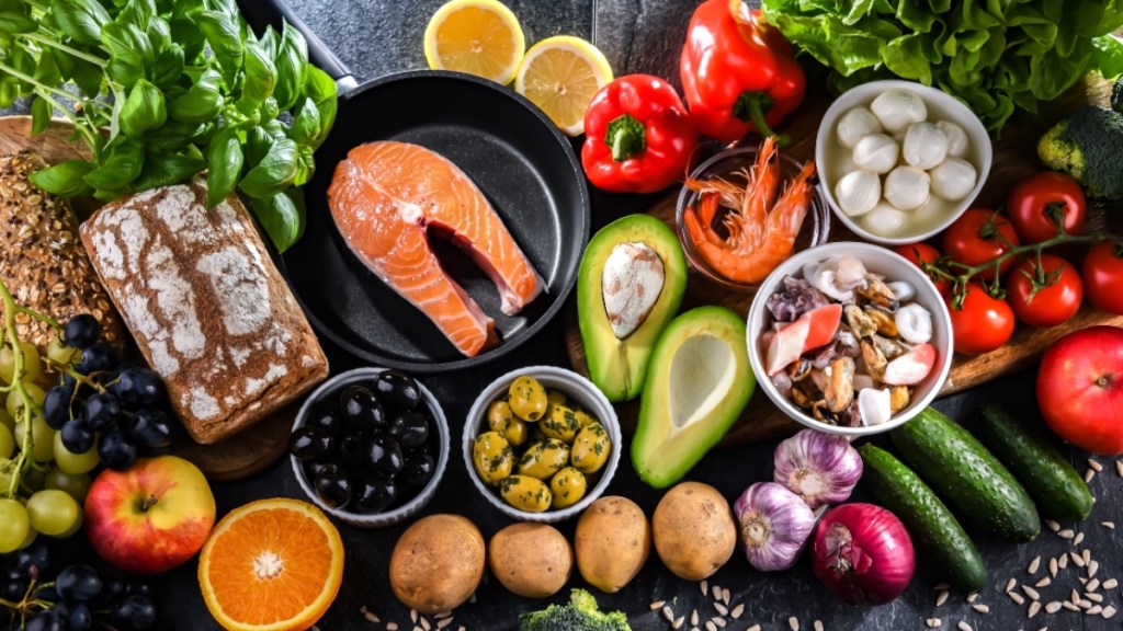 A table full of foods on the Mediterranean diet, such as fish, avocados, fruits and vegetables, which help ward off macular degeneration