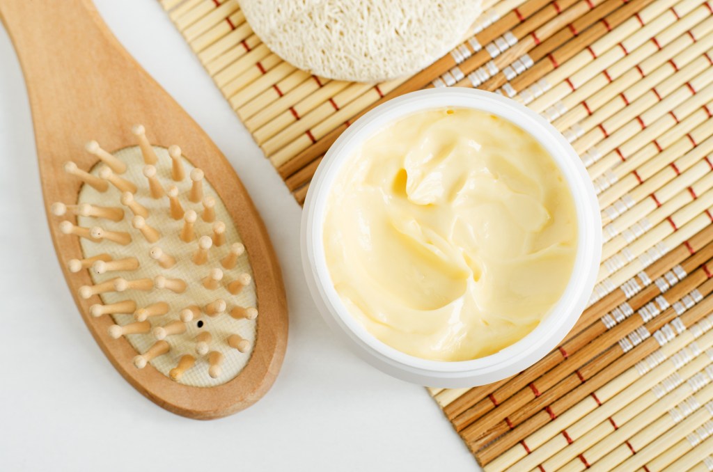 overview of hair mask with shea butter next to scalp brush