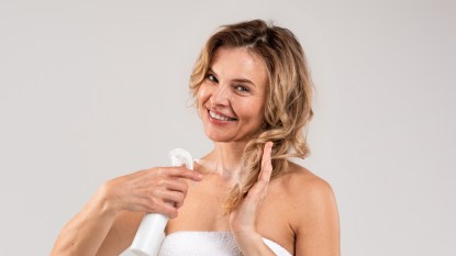 Mature woman smiling spraying hair with water for hair cycling.