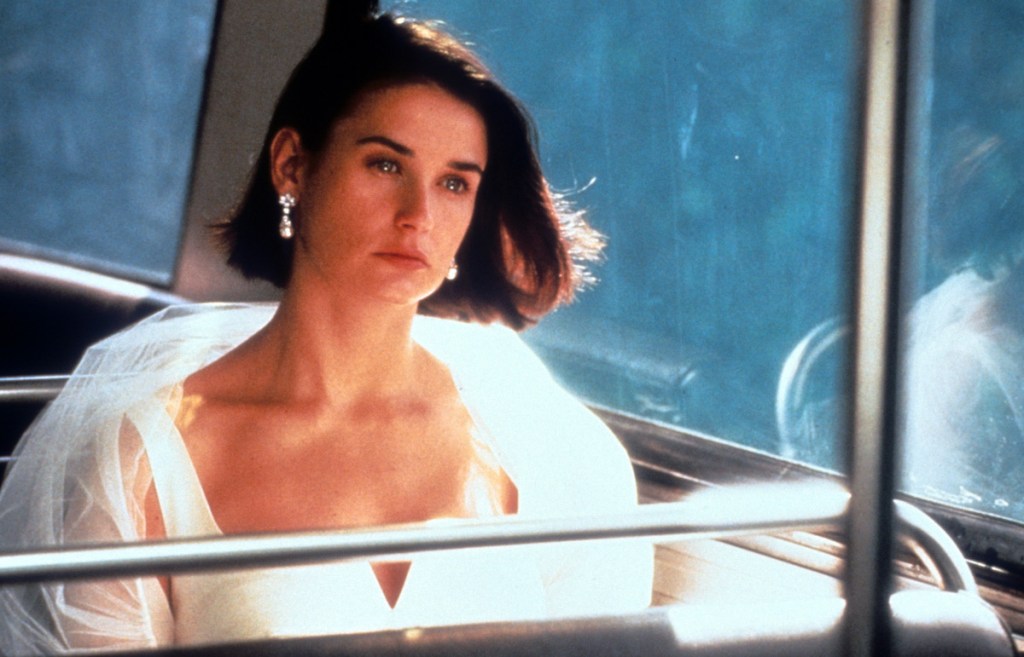 Demi Moore riding public transportation while dressed in formal wear in a scene from the film 'Indecent Proposal', 1993