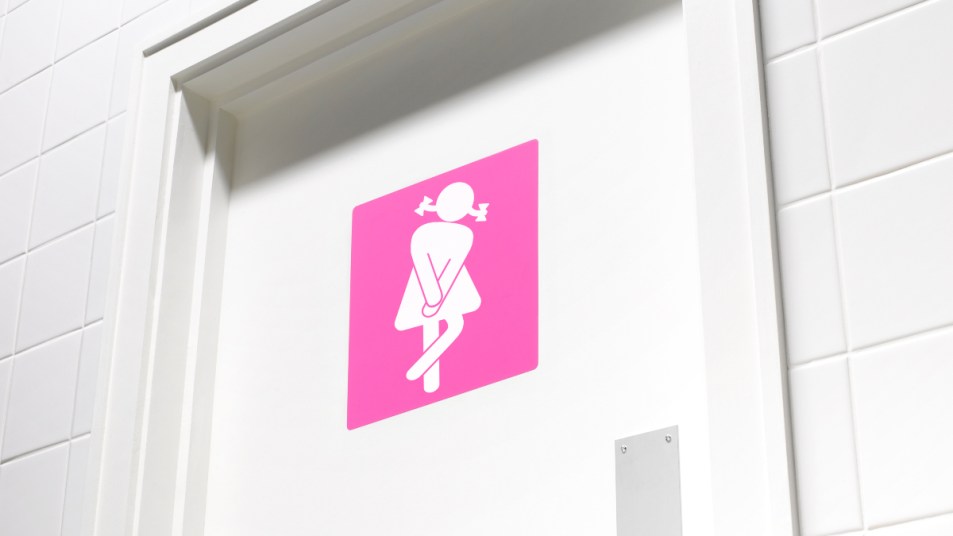 A women's bathroom door with an illustration of a woman crossing her legs