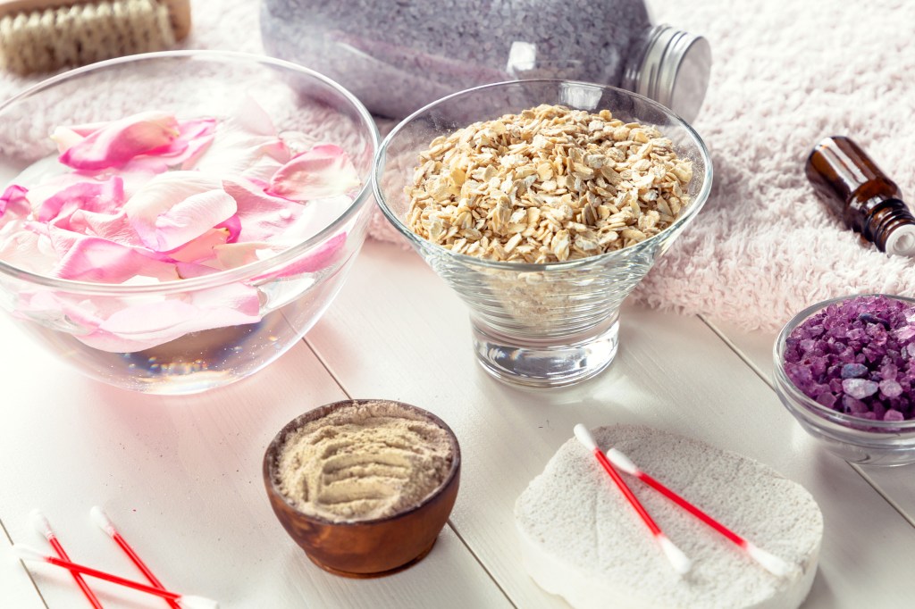 Bowl of rose water and bowl of oatmeal for bath salt recipes.