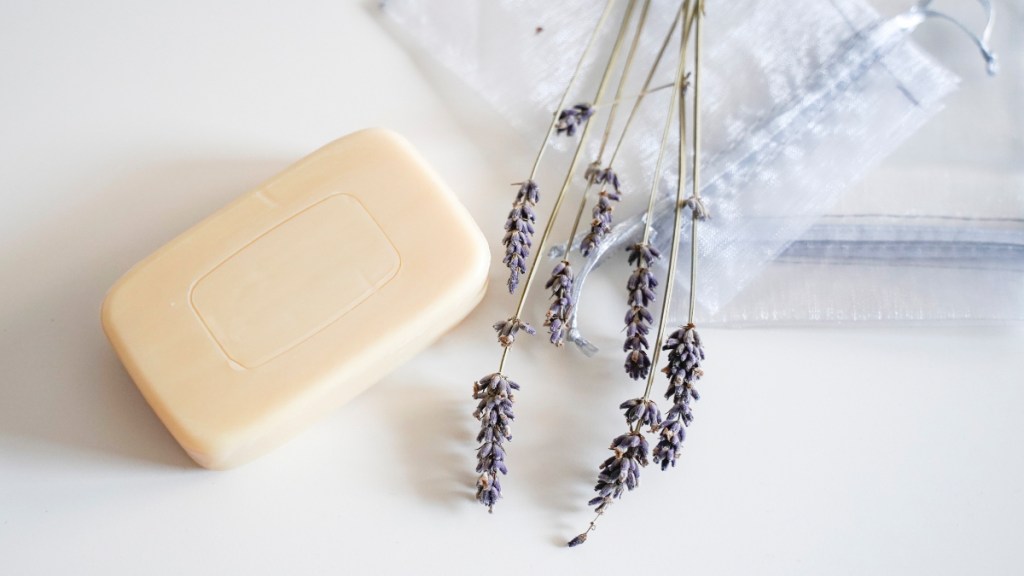 A bar of soap, which can help with breast eczema, on a white background beside lavender