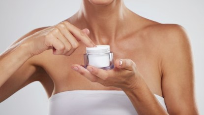 Woman holding moisturizer for skin flooding