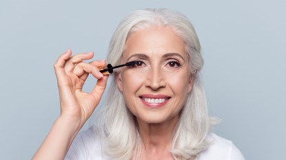 Woman applying the best mascara for thin lashes