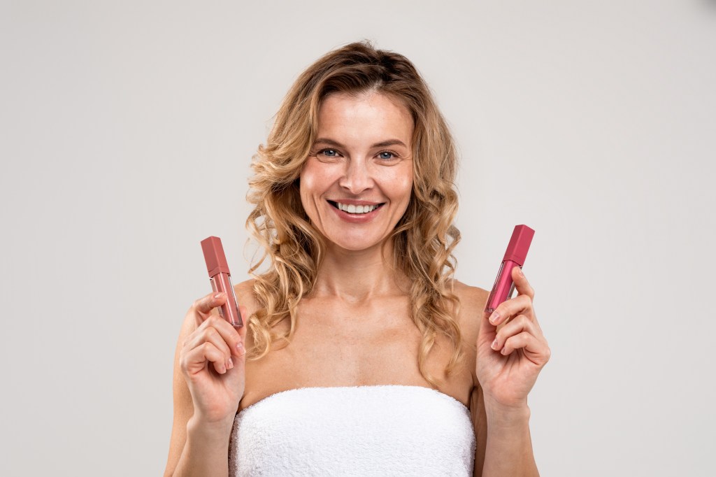mature woman holding lip products