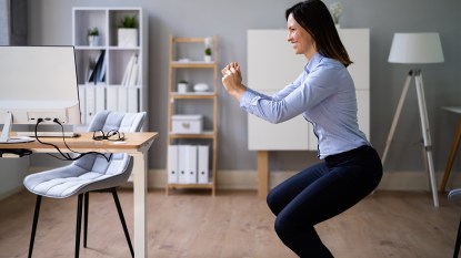 woman doing squats in her office; desk exercises