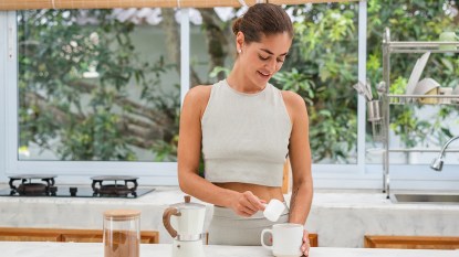 woman adding supplements to her coffee; coffee loophole