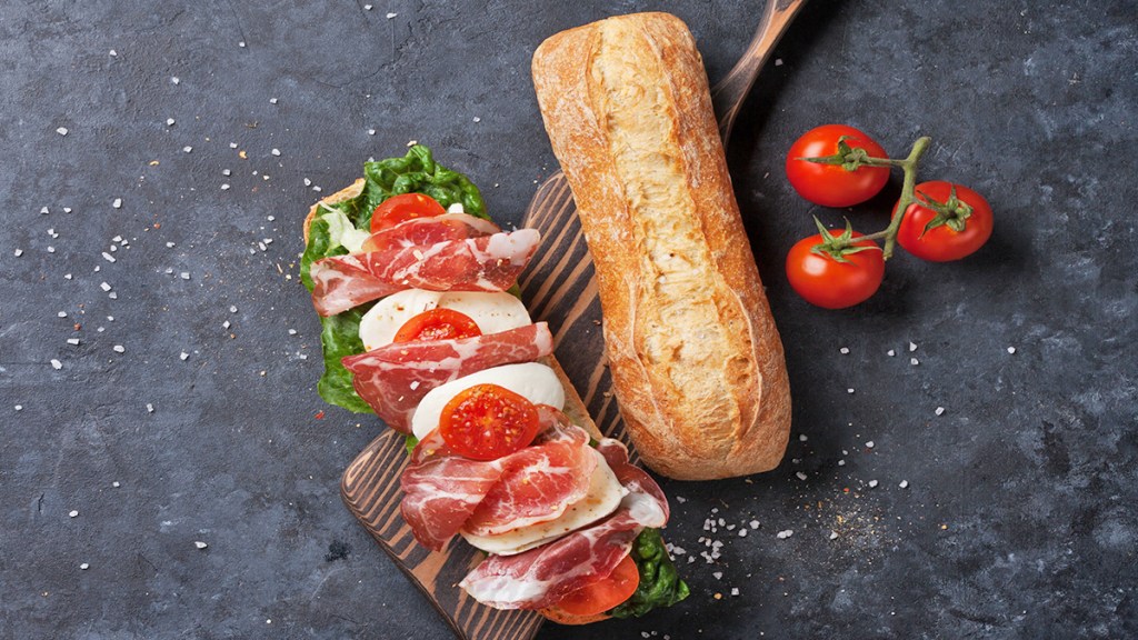 Prosciutto and mozzarella sandwiches that contain leaves of red leaf lettuce
